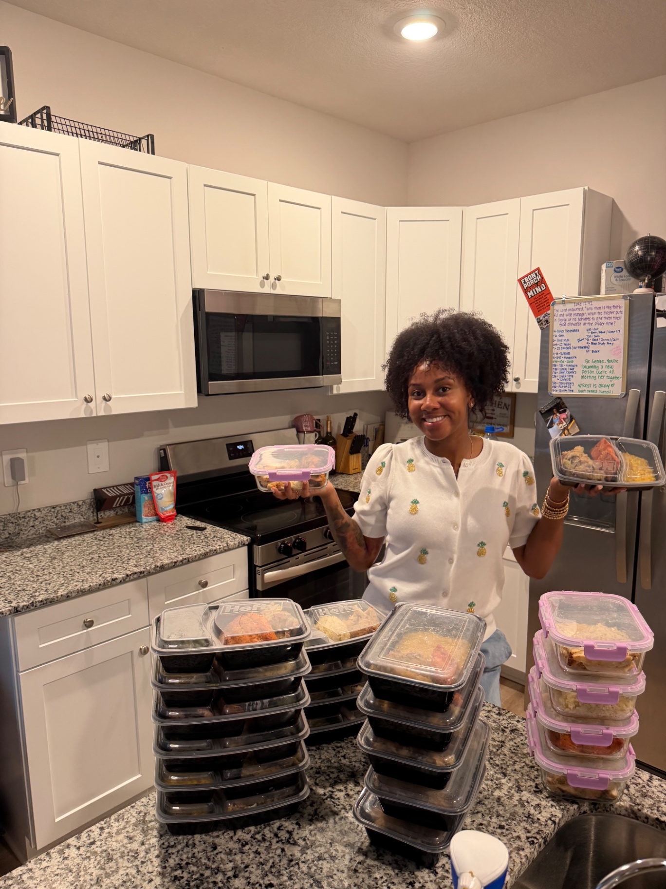 Founder holding freshly prepped DEM meal containers in the kitchen