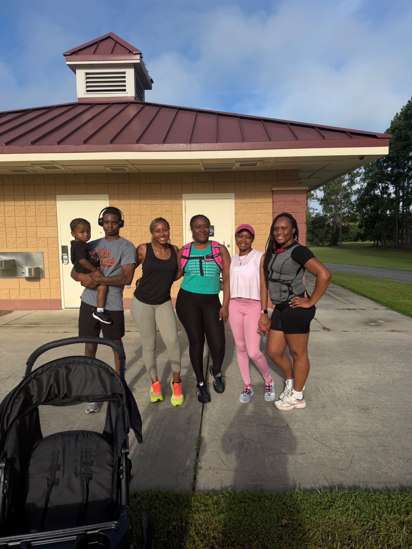D.E.M Run Club crew posing together at the park pavilion